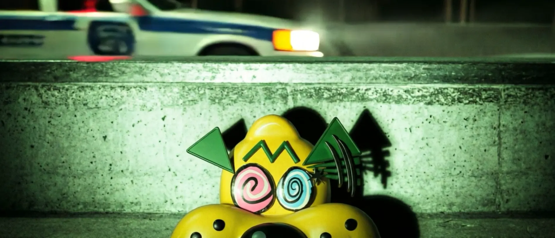 Rollo Eyes: the brand mascot peeking over a concrete ledge at night as a police car streaks past behind